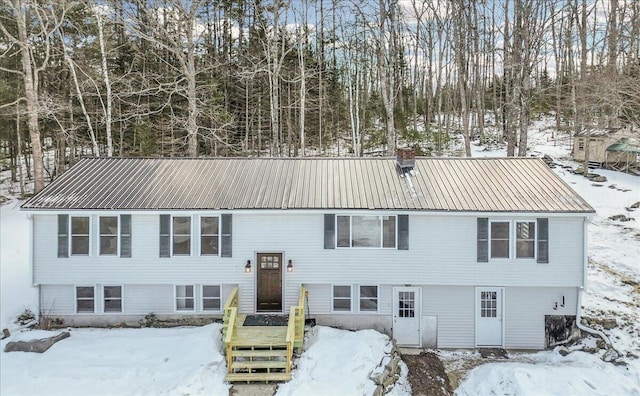 split foyer home featuring a chimney and metal roof