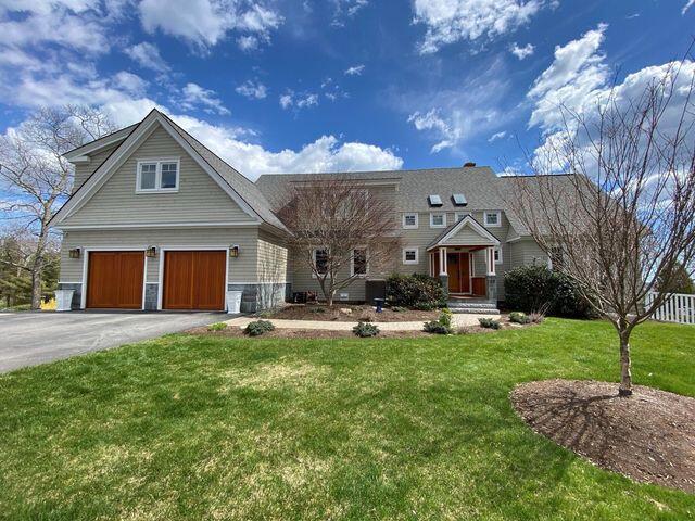 view of front of home featuring driveway, a front lawn, and an attached garage