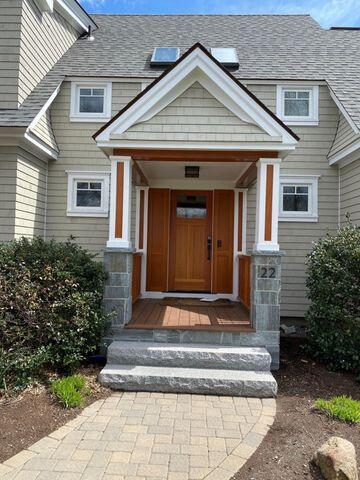 view of exterior entry featuring a shingled roof