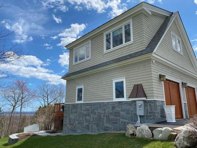 view of side of home with a garage and stone siding