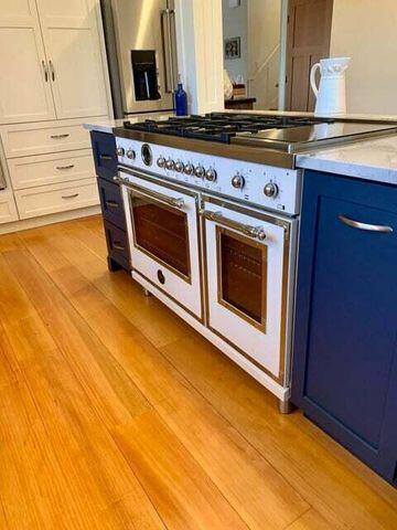 kitchen with light countertops, light wood finished floors, white cabinetry, and double oven range