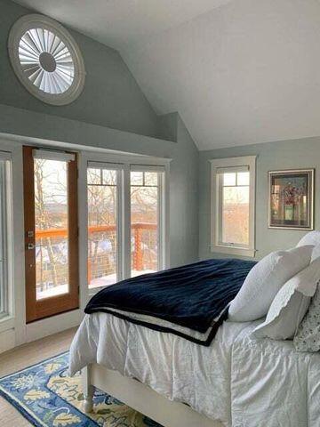 bedroom featuring lofted ceiling, multiple windows, and access to exterior