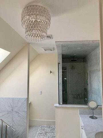 bathroom with baseboards, visible vents, walk in shower, and vanity