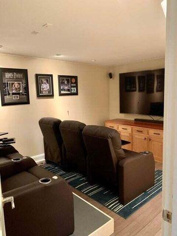 home theater with light wood finished floors and baseboards