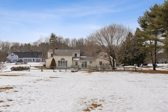 snow covered back of property with fence