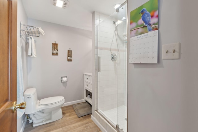 full bath featuring visible vents, a shower stall, toilet, and wood finished floors