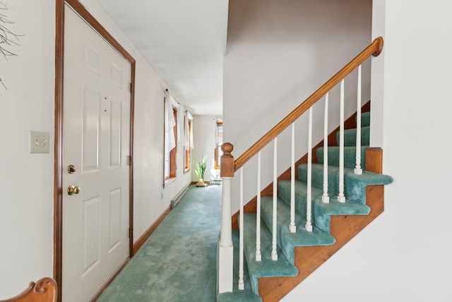 carpeted foyer featuring stairs, baseboards, and a baseboard radiator