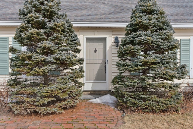 property entrance featuring a shingled roof