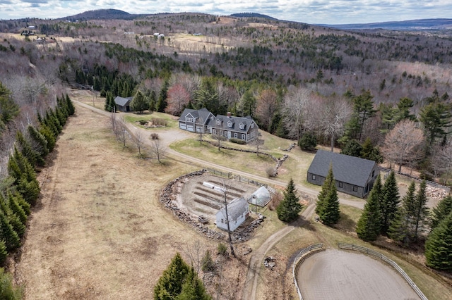 birds eye view of property with a wooded view and a mountain view