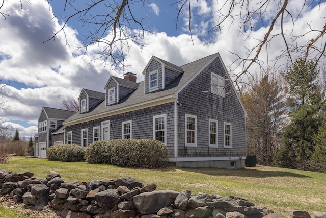 view of side of property with a lawn, an attached garage, and central air condition unit