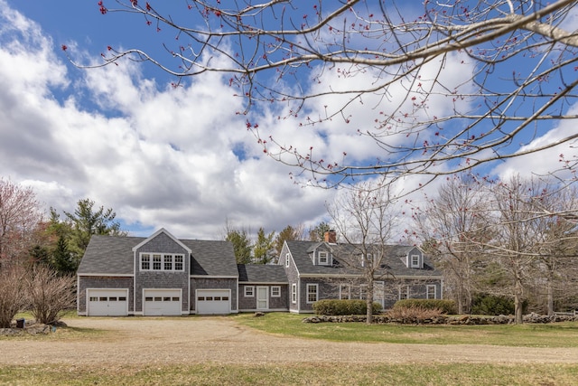 view of front of house featuring an attached garage, roof with shingles, dirt driveway, and a front lawn