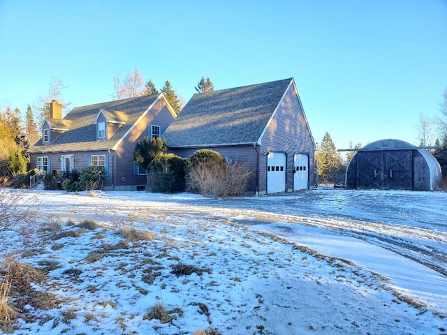 view of front of home with a detached garage and a chimney