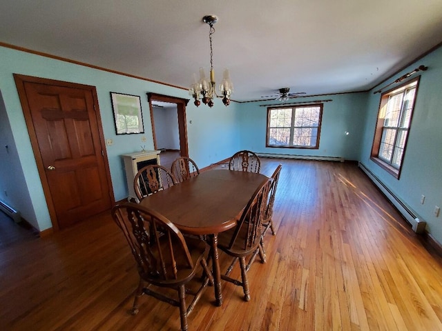 dining room featuring light wood-type flooring, a baseboard radiator, a notable chandelier, and ornamental molding