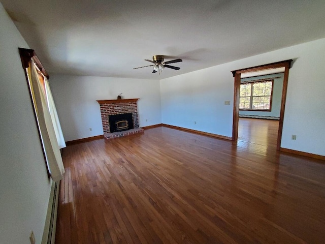 unfurnished living room featuring a brick fireplace, baseboards, and dark wood-style flooring