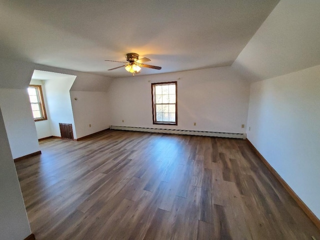 bonus room featuring a baseboard heating unit, dark wood-style flooring, lofted ceiling, and baseboards