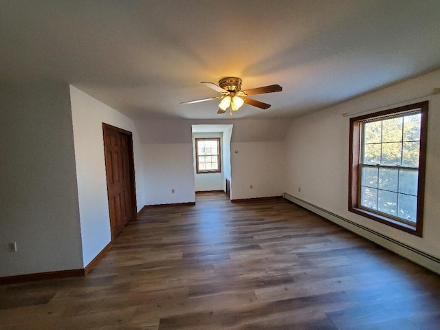 empty room with dark wood-style flooring, baseboards, ceiling fan, and baseboard heating