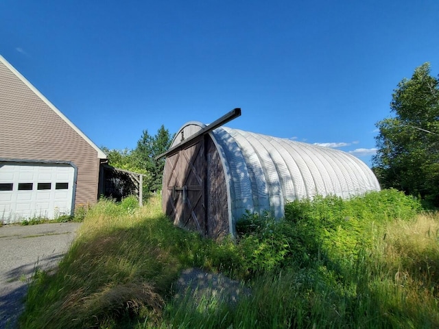 view of home's exterior featuring a garage and an outbuilding