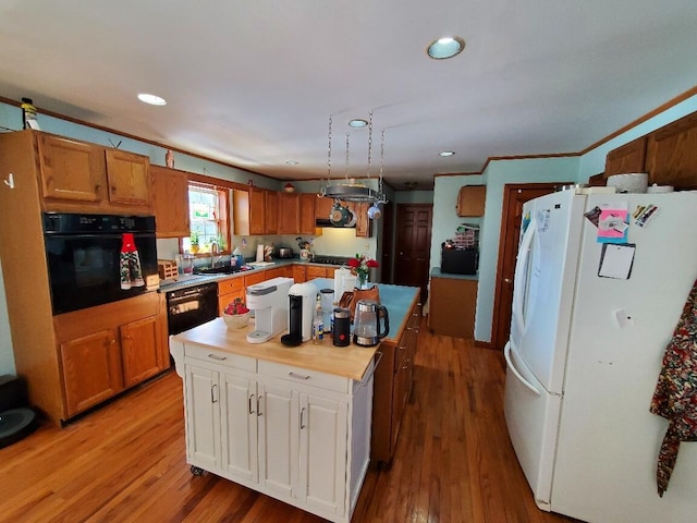 kitchen with a center island, light countertops, brown cabinetry, a sink, and black appliances