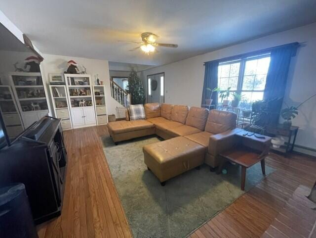 living room featuring ceiling fan, stairway, and wood finished floors