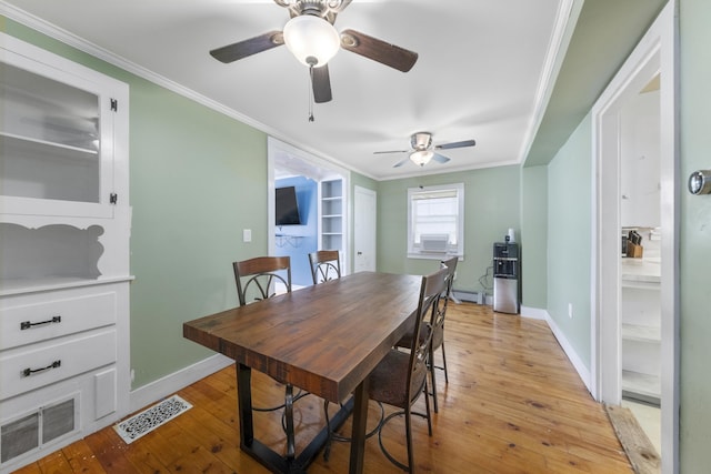 dining space featuring ornamental molding, light wood-type flooring, and visible vents