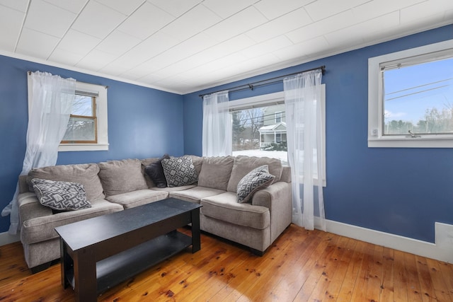 living room featuring ornamental molding, plenty of natural light, wood-type flooring, and baseboards