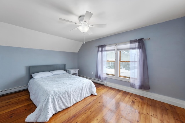 bedroom featuring a baseboard heating unit, vaulted ceiling, hardwood / wood-style flooring, and a ceiling fan