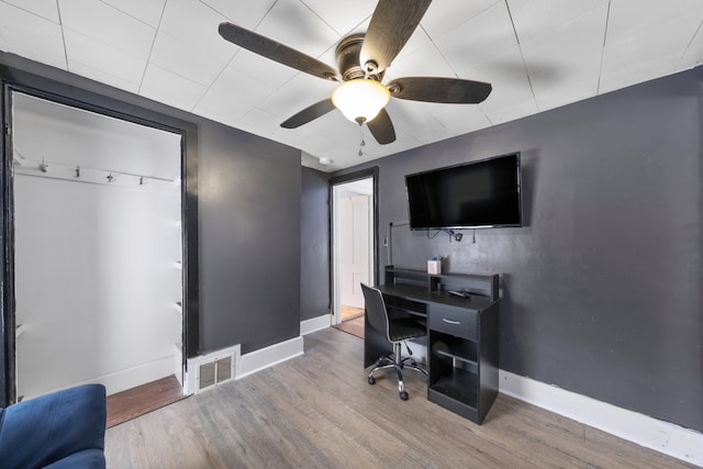 office featuring a ceiling fan, wood finished floors, visible vents, and baseboards