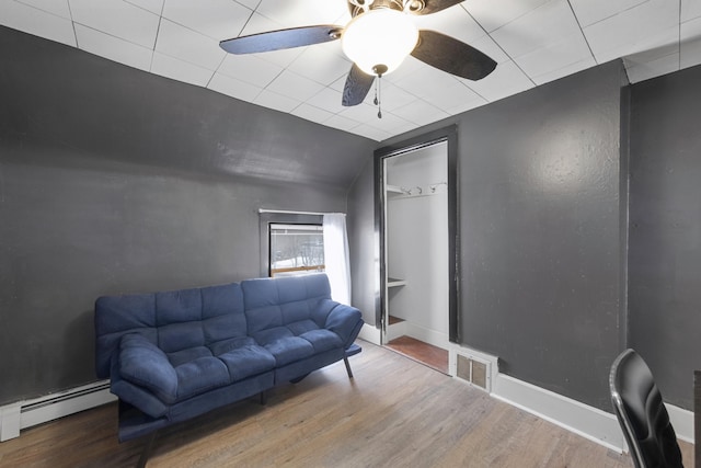 living area featuring visible vents, baseboards, a ceiling fan, wood finished floors, and baseboard heating