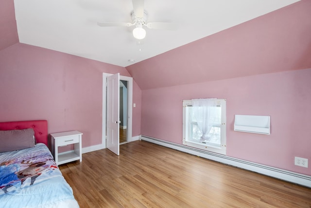 unfurnished bedroom with a baseboard radiator, light wood-style flooring, a ceiling fan, vaulted ceiling, and baseboards