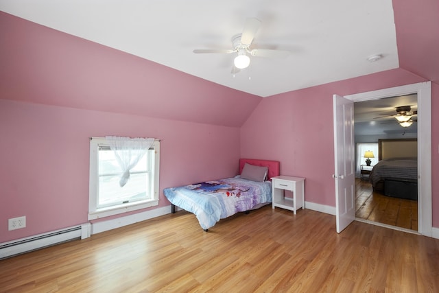 bedroom featuring baseboards, ceiling fan, vaulted ceiling, light wood-type flooring, and a baseboard heating unit