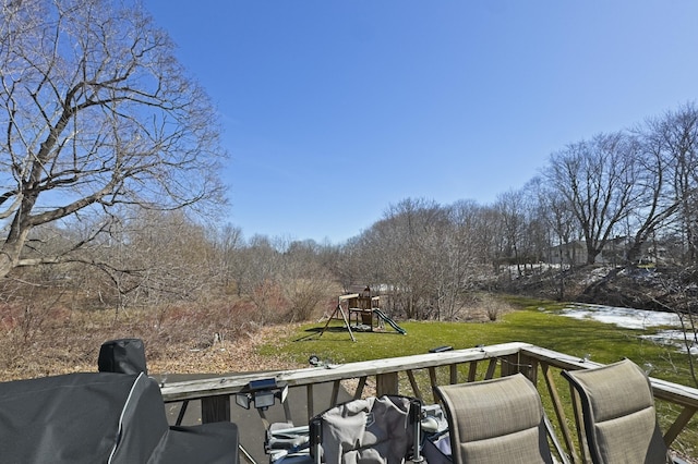 deck featuring a playground and a lawn