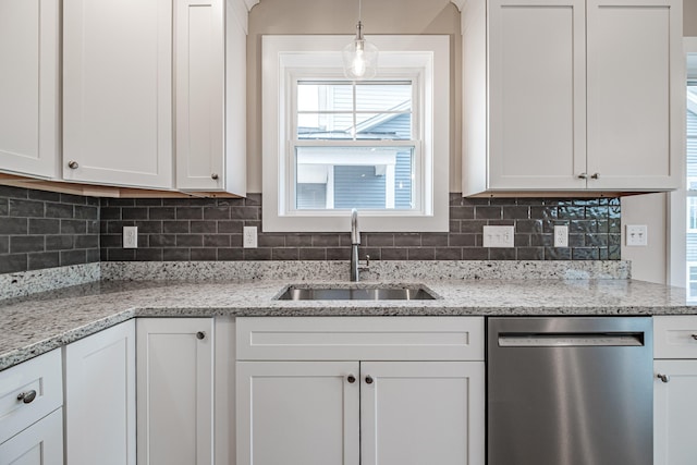 kitchen with white cabinets, dishwasher, light stone counters, decorative light fixtures, and a sink