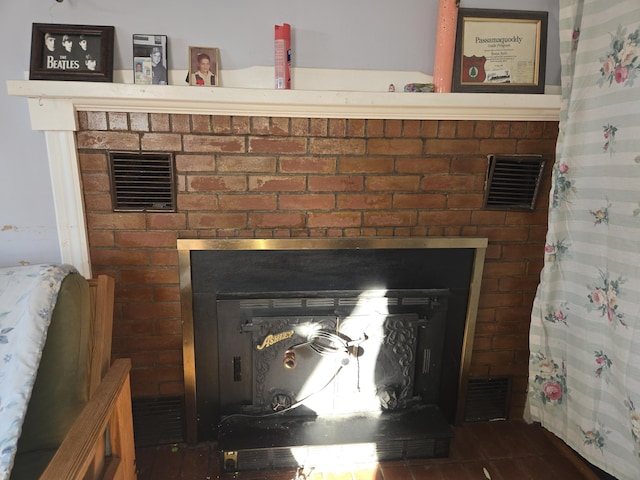 details featuring a brick fireplace and visible vents