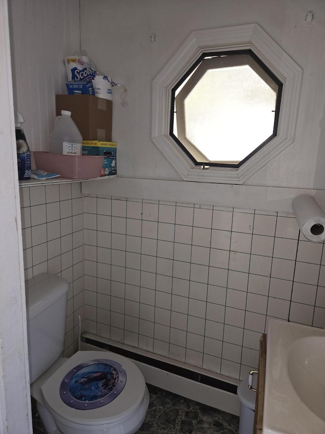 bathroom with toilet and tile walls