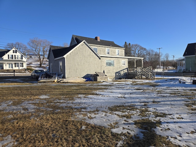 snow covered property featuring a chimney