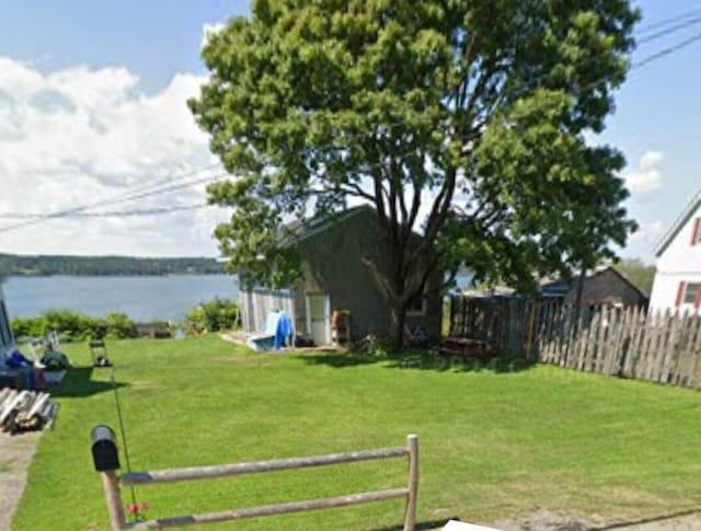 view of yard with a water view and fence