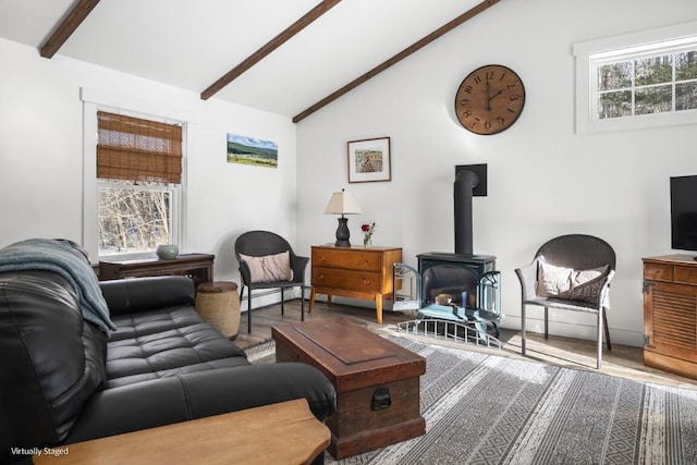 living area featuring a wood stove, vaulted ceiling with beams, baseboard heating, and wood finished floors