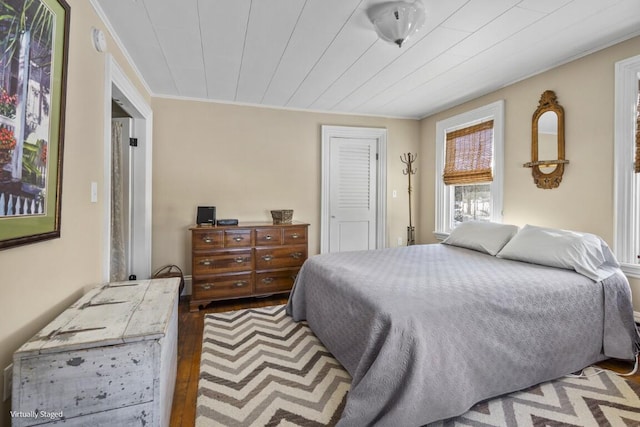 bedroom featuring dark wood-type flooring and crown molding