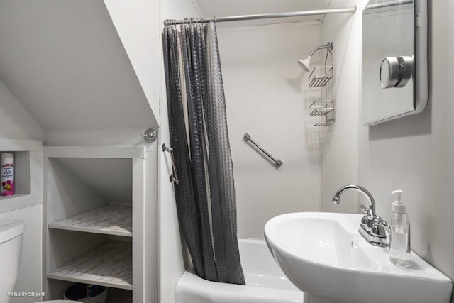 bathroom with toilet, a sink, and shower / tub combo with curtain