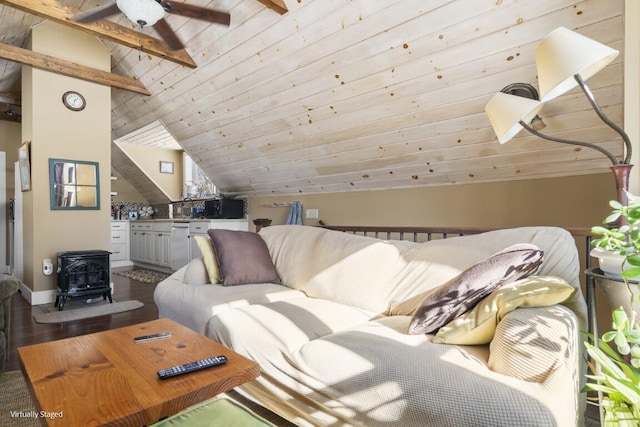 interior space with dark wood finished floors, a ceiling fan, lofted ceiling, wood ceiling, and a wood stove