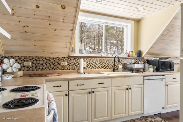 kitchen with light countertops, white appliances, a sink, and decorative backsplash