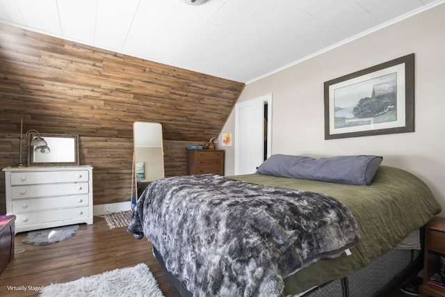 bedroom with lofted ceiling, dark wood-style floors, crown molding, and wood walls