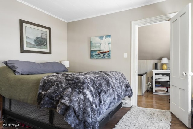 bedroom with ornamental molding and dark wood finished floors