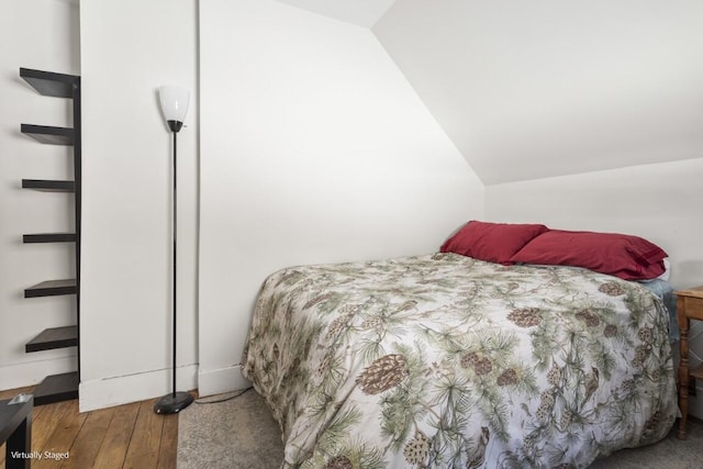 bedroom featuring lofted ceiling and hardwood / wood-style flooring