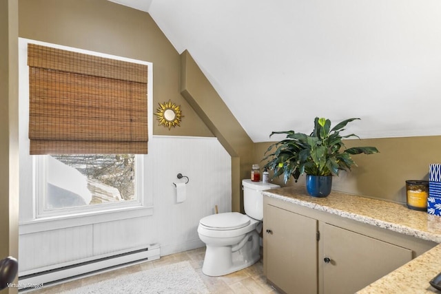 half bath with a baseboard radiator, a wainscoted wall, vaulted ceiling, and toilet