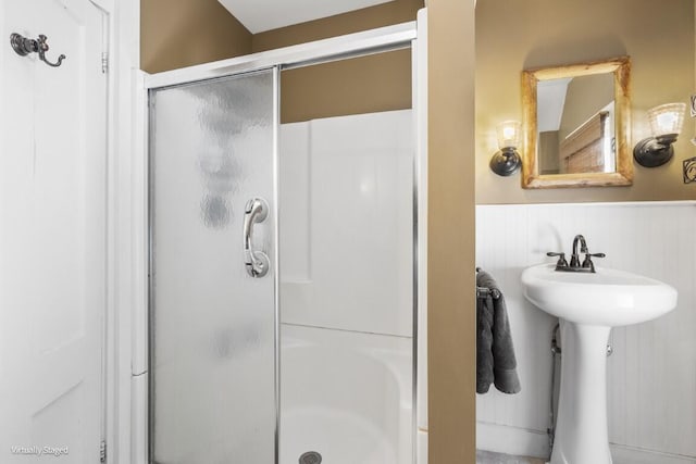 bathroom featuring a shower stall and wainscoting