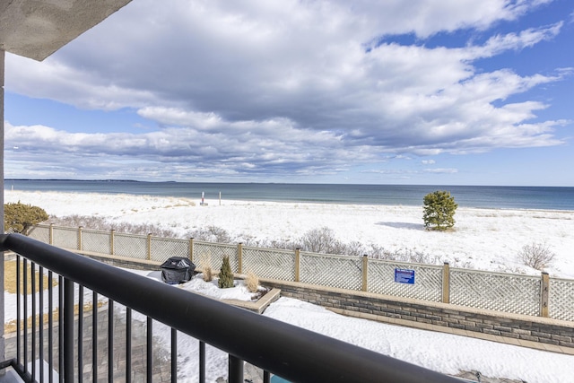 view of water feature with a beach view and fence