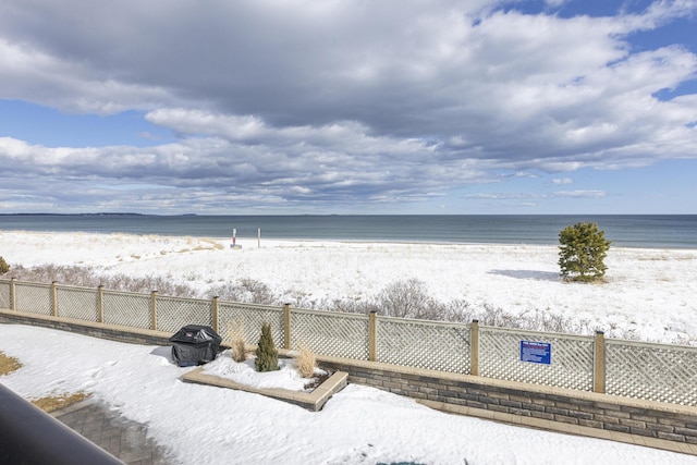 view of water feature featuring fence and a view of the beach