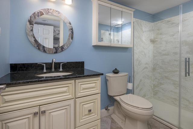 full bathroom featuring a stall shower, baseboards, toilet, tile patterned flooring, and vanity