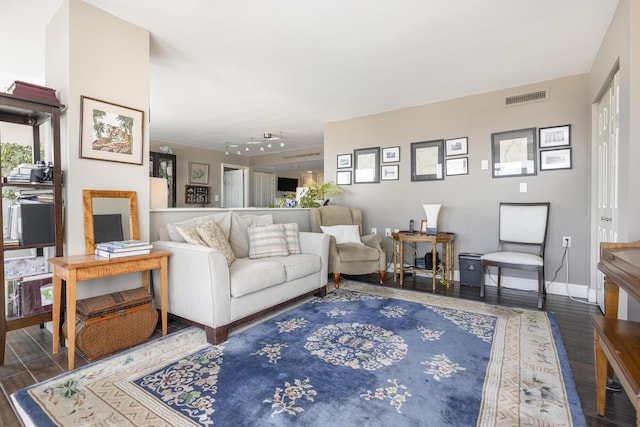 living area featuring rail lighting, baseboards, visible vents, and wood finished floors